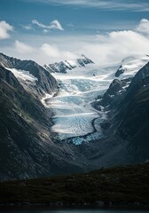 Majestic glacier clinging to a towering mountain range under a vast sky, showcasing ancient ice formations and rugged wilderness ,frozen ,chilly ,high