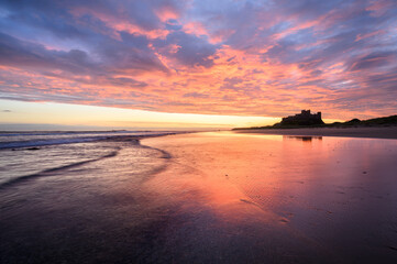 Dramatic sunrise above beach at Bamburgh Castle on The Northumberland Coast, UK. © _Danoz