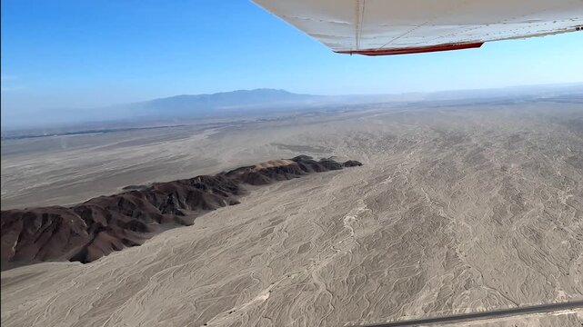 An aerial view from a small plane flying over the mysterious Nazca Lines and the Pan-American Highway in Peru. These ancient geoglyphs are a UNESCO World Heritage site
