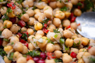 Nahaufnahme eines frischen Kichererbsensalats mit Petersilie, Paprika, Zwiebeln und Kr&auml;utern, bunte Farben, gesunde Zutaten.