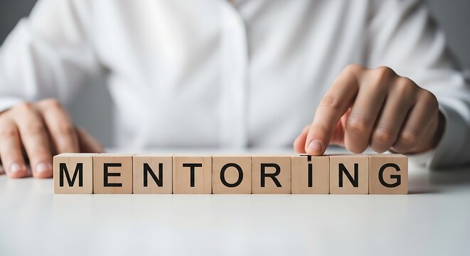 Person arranging wooden blocks spelling out the word mentoring, symbolizing guidance and support in professional development - Powered by Adobe