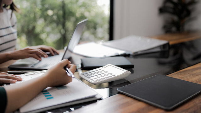 Business administrator reviewing financial reports and marketing analysis for company sales growth and strategy development - Powered by Adobe