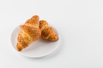 two croissants in a plate on a white isolated background