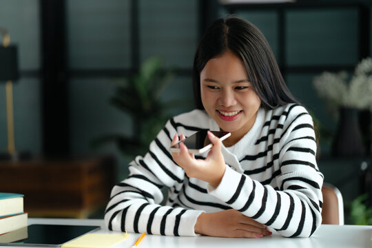 Asian woman using voice assistant AI learning on smartphone