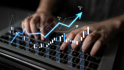 A pair of hands typing on a laptop keyboard with an overlay of financial graphs, illustrating growth and progress in business and investment analysis. Scalp
