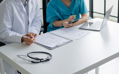 Doctor and nurse consulting on patient medical record in hospital