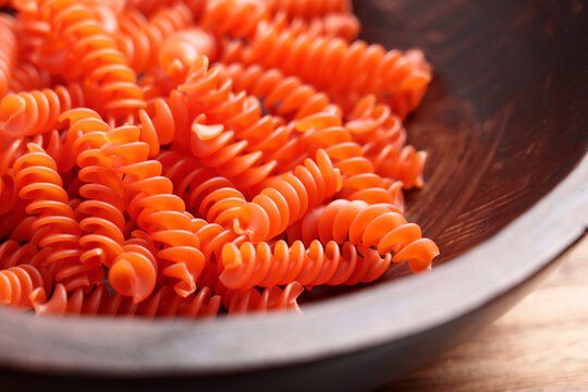 Orange lentil fusilli pasta in a bowl. Uncooked organic ingredient