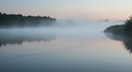 Fototapeta premium Serene river landscape features dense mist settling over still water near forested banks at dawn