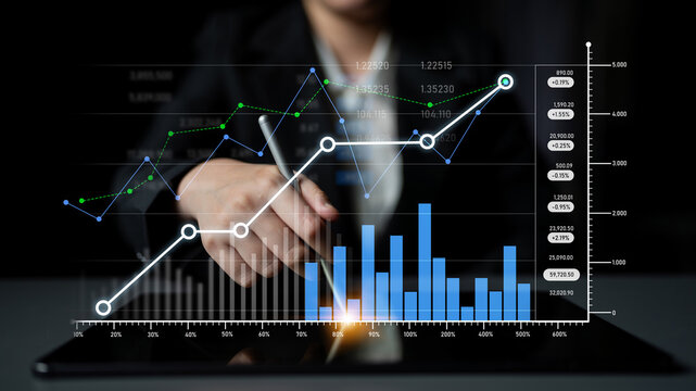 A business professional conducts financial analysis using charts and graphs in a modern office. The image highlights trends and data-driven decision-making in finance. Scalp