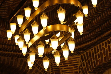 Retro style electric chandeliers in interior of a brick structure at Istanbul