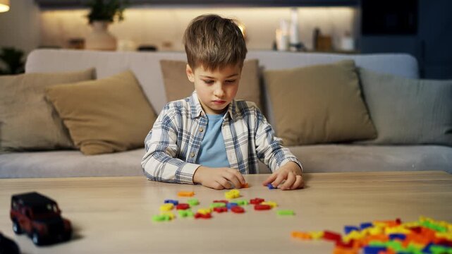 Thoughtful little boy solving math equation using toy number set, education