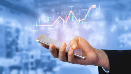 A business professional uses a smartphone to track financial data, showcasing an upward trend graph that symbolizes investment growth and modern technology. Scalp