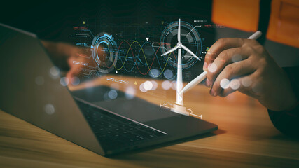 Engineer using digital tablet to analyze renewable energy data with wind turbine model and futuristic interface, representing smart technology innovation in sustainable power solutions.