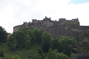 Edinburgh Castle towering on a hilltop, a historic medieval stone fortress dominating the Scottish skyline, showcasing ancient architecture, battlements, ramparts and enduring heritage of Scotland