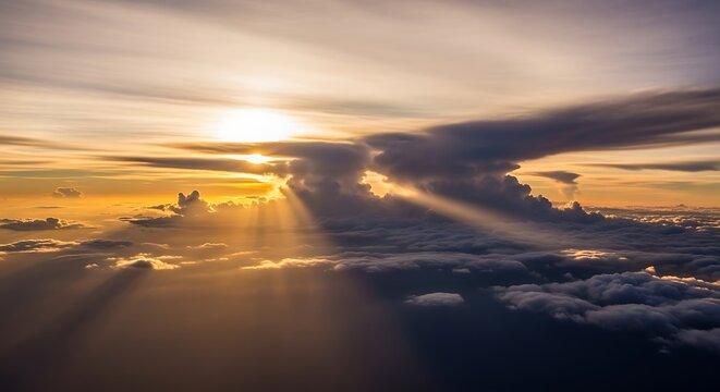 Dramatic sunbeams pierce through storm clouds at sunset above the ocean