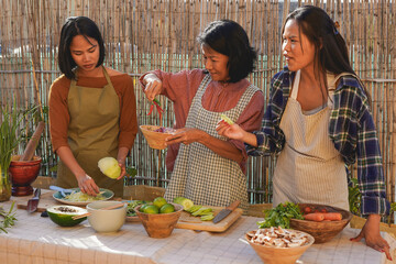 Happy thai ethnic mother cooking with daughter outdoor - Traditional food, asian culture and family love concept