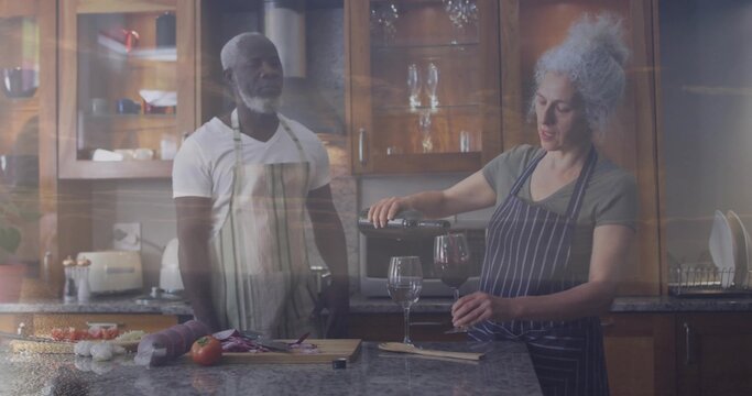 Pouring woman in striped apron pouring wine from bottle into glass in home kitchen, cutting board