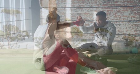 Doing situps on turf, male in hoodie giving high-five, woman in tank and leggings, green kettlebell