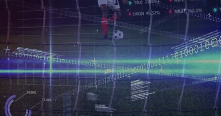 Standing soccer-player red-socked placing foot by ball on pitch at night, net and digital overlays