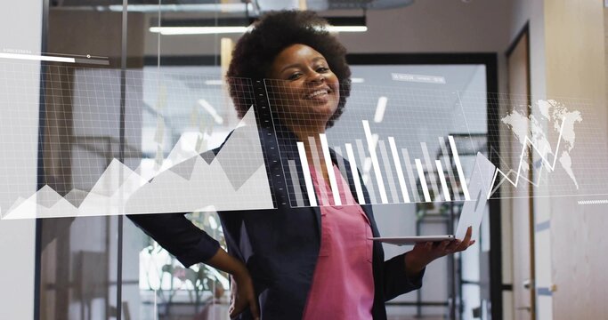 Analyzing analyst in dark blazer pink blouse in office hallway, holding slim laptop with AR charts