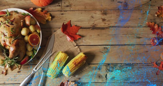 Fototapeta Sitting roasted chicken with rosemary and citrus on wood plank near blue paint splatter, copy space