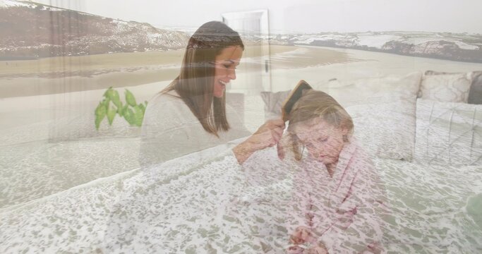 Brushing mother tending child's hair at home on light sofa, hairbrush, striped robe, sea overlay - Powered by Adobe
