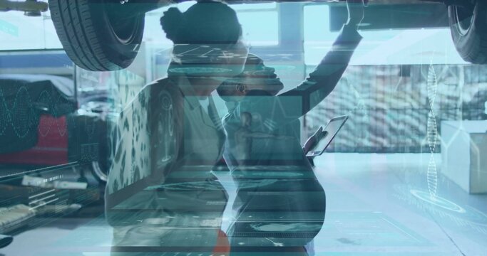 Inspecting two female techs in workwear checking car on lift in auto shop, with tablet holographics