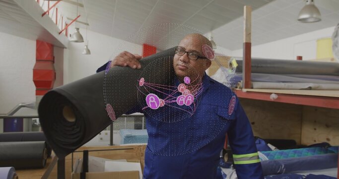 Carrying man in blue coveralls and glasses moving black roll in textile workshop, hologram - Powered by Adobe