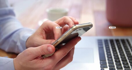 Tapping smartphone, adult hands in blue dress shirt operating laptop on wooden desk, ceramic mug