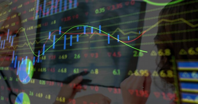Displaying financial charts overlaying two women in business attire at desk with tablet stylus - Powered by Adobe