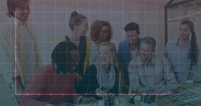 Leaning team reviewing layouts at large office table in sweaters, using laptop and swatches - Powered by Adobe