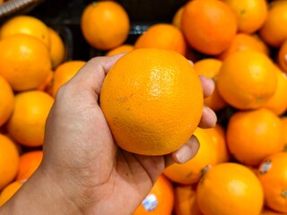 Close-up of bright, juicy oranges, showcasing their rich color and inviting texture in a market setting.