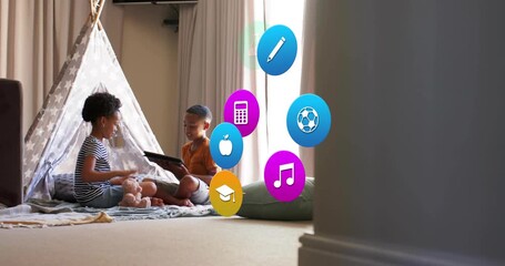 Boy tapping tablet on blanket, girl showing teddy, causing education icons clustering between kids