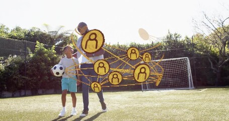Dad and boy entering, causing gold network orbiting in front, with soccer ball, practicing sports - Powered by Adobe