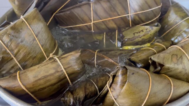 Traditional Latin American Hallacas Wrapped in Plantain Leaves Boiling in a Pot for Christmas Dinner