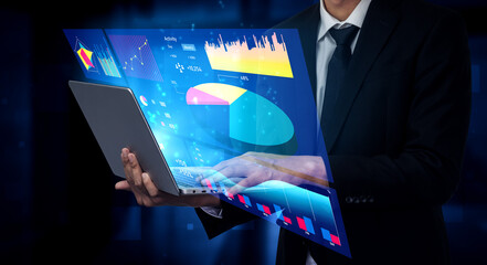 A businessman holds an advanced laptop displaying colorful data visualizations and graphs, symbolizing modern analytics and effective decision-making in business. Impute