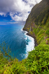 Majestic Waterfall Cascading Down Lush Green Cliffs, Madeira island, Portugal, nature background or travel wallpaper