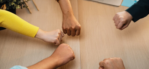 Vibrant hands of diverse individuals united in a gesture of collaboration and support in a modern office, symbolizing partnership and teamwork in a professional setting. SACTR