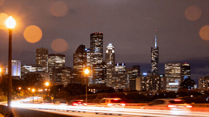 Nighttime city skyline with illuminated skyscrapers and traffic light trails