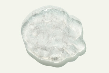 Lip gloss transparent or oil gel with pink shimmer texture smudge on gray isolated background