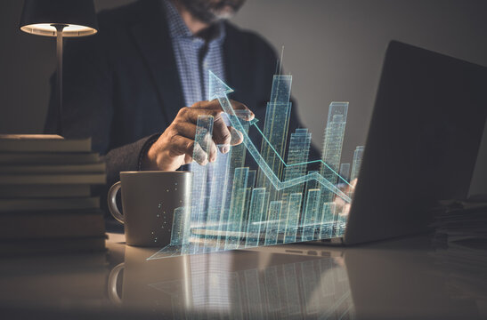Businessman analyzing real estate financial growth on a futuristic holographic data display