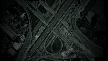 Aerial surveillance, military reconnaissance view of a complex highway interchange with HUD targeting graphics, creating a cinematic spy-drone atmosphere and intelligence-operation mood