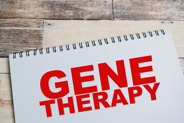 Concept of gene therapy write on book isolated on Wooden Table. To prevent or cure a disease or...