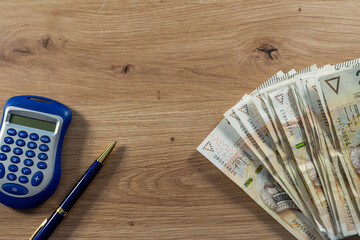 200 Polish zloty money with blue calculator on desk, finance accounting, budgeting and investment concept