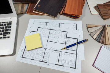 Interior designer workplace with laptop, house plan and wooden samples, home planning concept