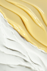 Cosmetic beauty product texture sample swatch. Two products mix. Beige yellow gel serum mask or peeling and milky white cream balm.