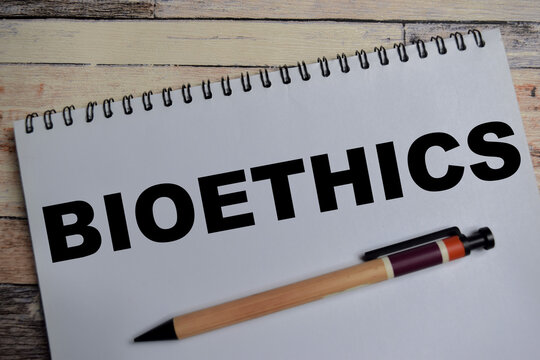 Concept of bioethics write on book isolated on Wooden Table. Study of ethical, social and legal issues