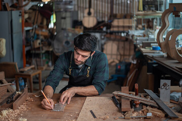 Luthier making guitar using traditional tools in workroom with manual tools