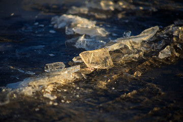 Broken Ice Pieces on Frozen Surface at Sunset