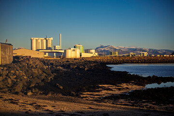 Industrial Buildings on Coastal Shore with Mountains, Iceland